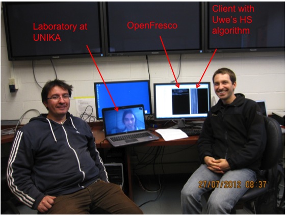 The testing team of Andreas Schellenberg and Selim Gunnay at UC Berkeley's nees@berkeley laboratory, pose for a photo with Professor Uwe Dorka who is virtually present from the civil engineering laboratory at the University of Kassel (UNIKA) in Germany.